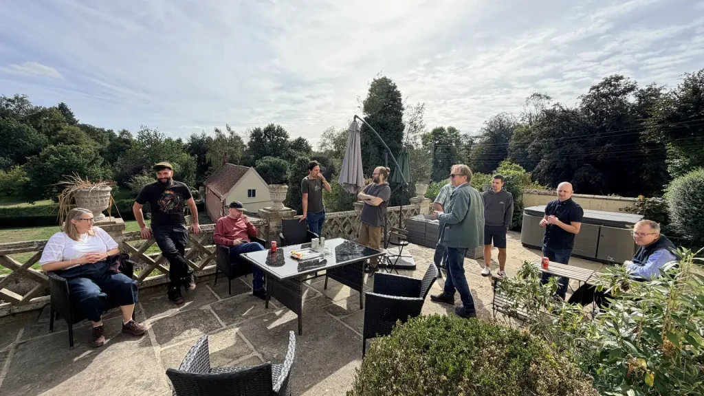 The team relaxing and chatting on the stone terrace at Holbecks House, overlooking the gardens.